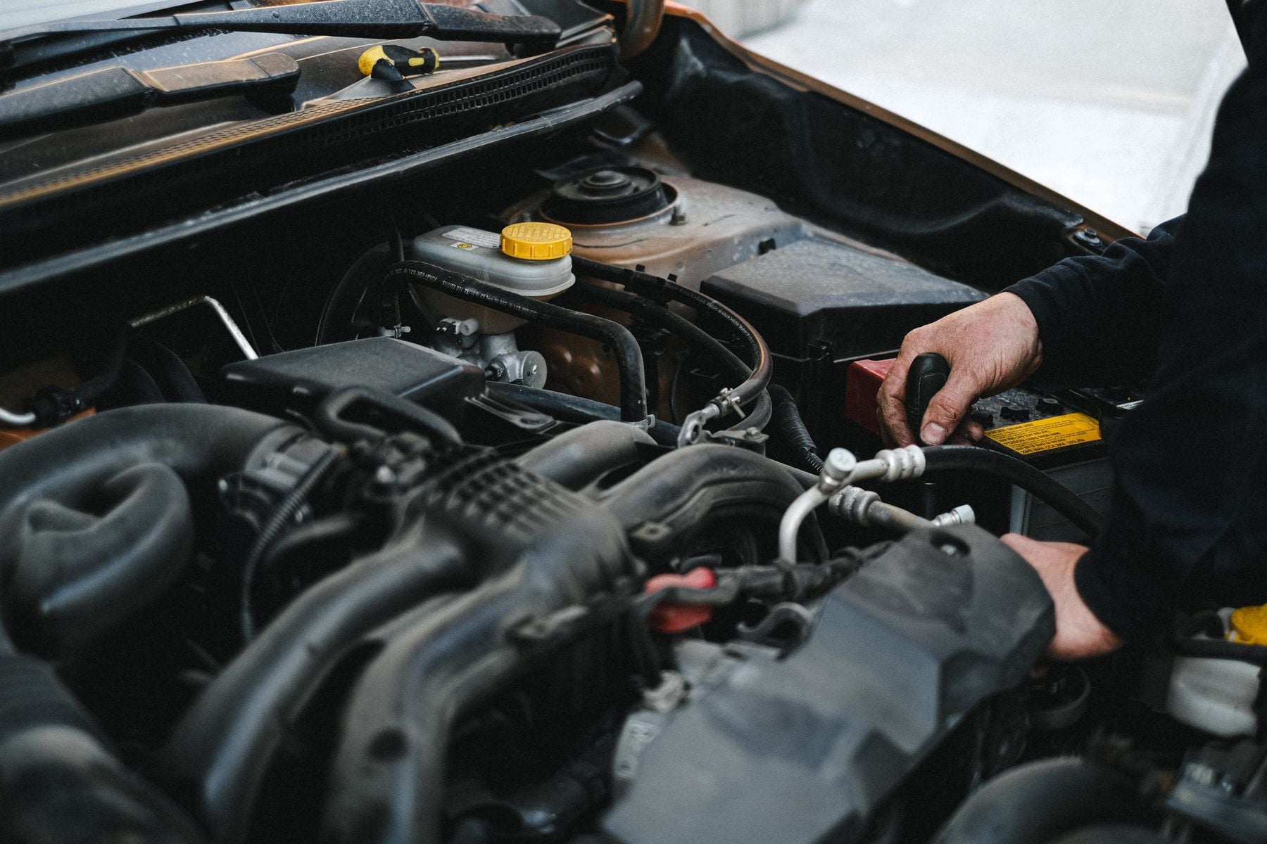 Automotive technician inspecting the engine compartment of a vehicle